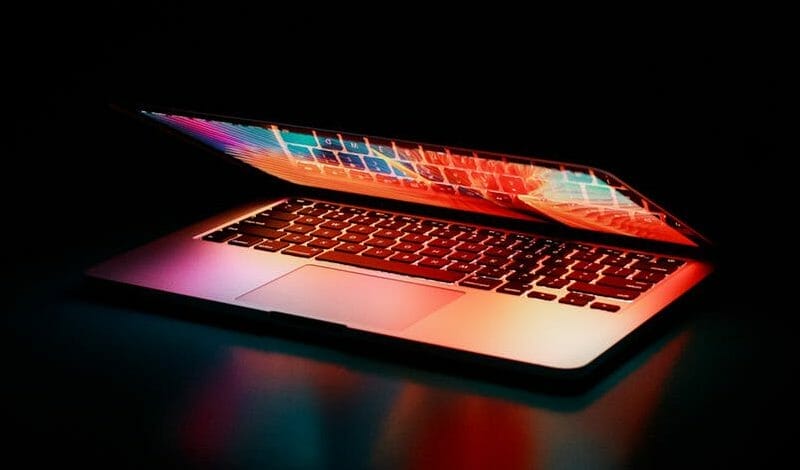 laptop half open showing rainbow screen of Jim2 Saas ERP Software