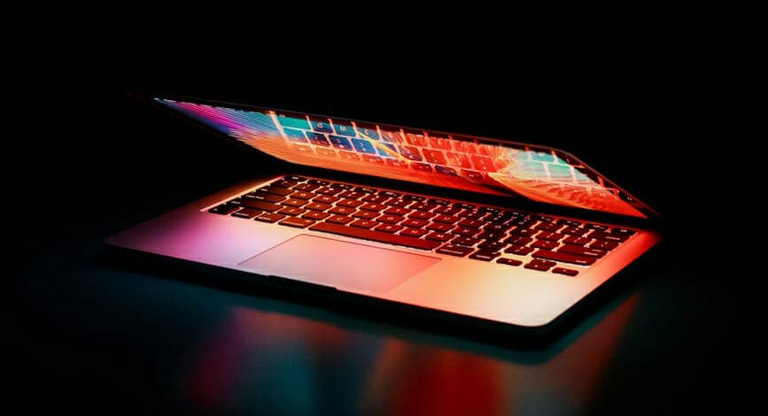 laptop half open showing rainbow screen of Jim2 Saas ERP Software