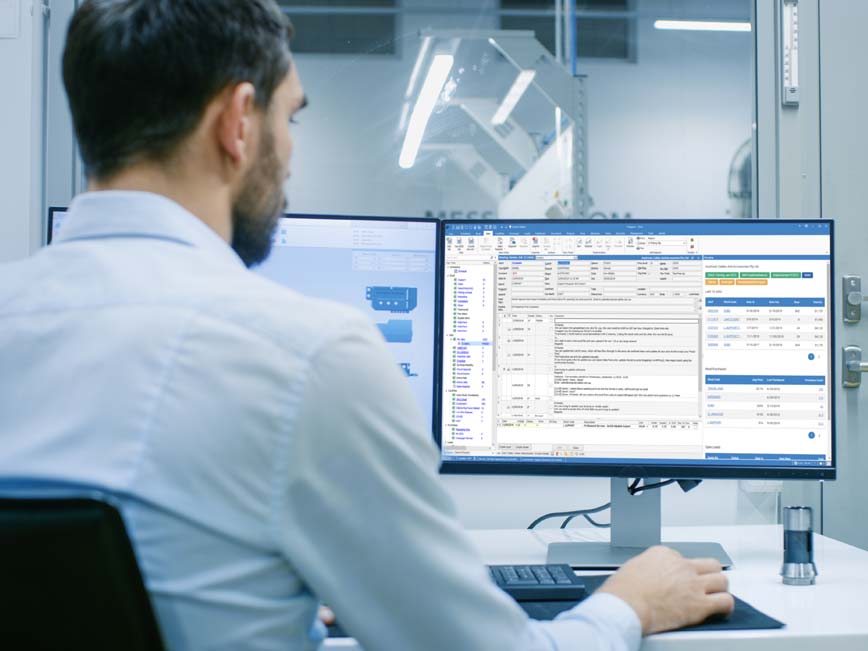 Duel montior man looking at screeen Jim2 ERP software and listings